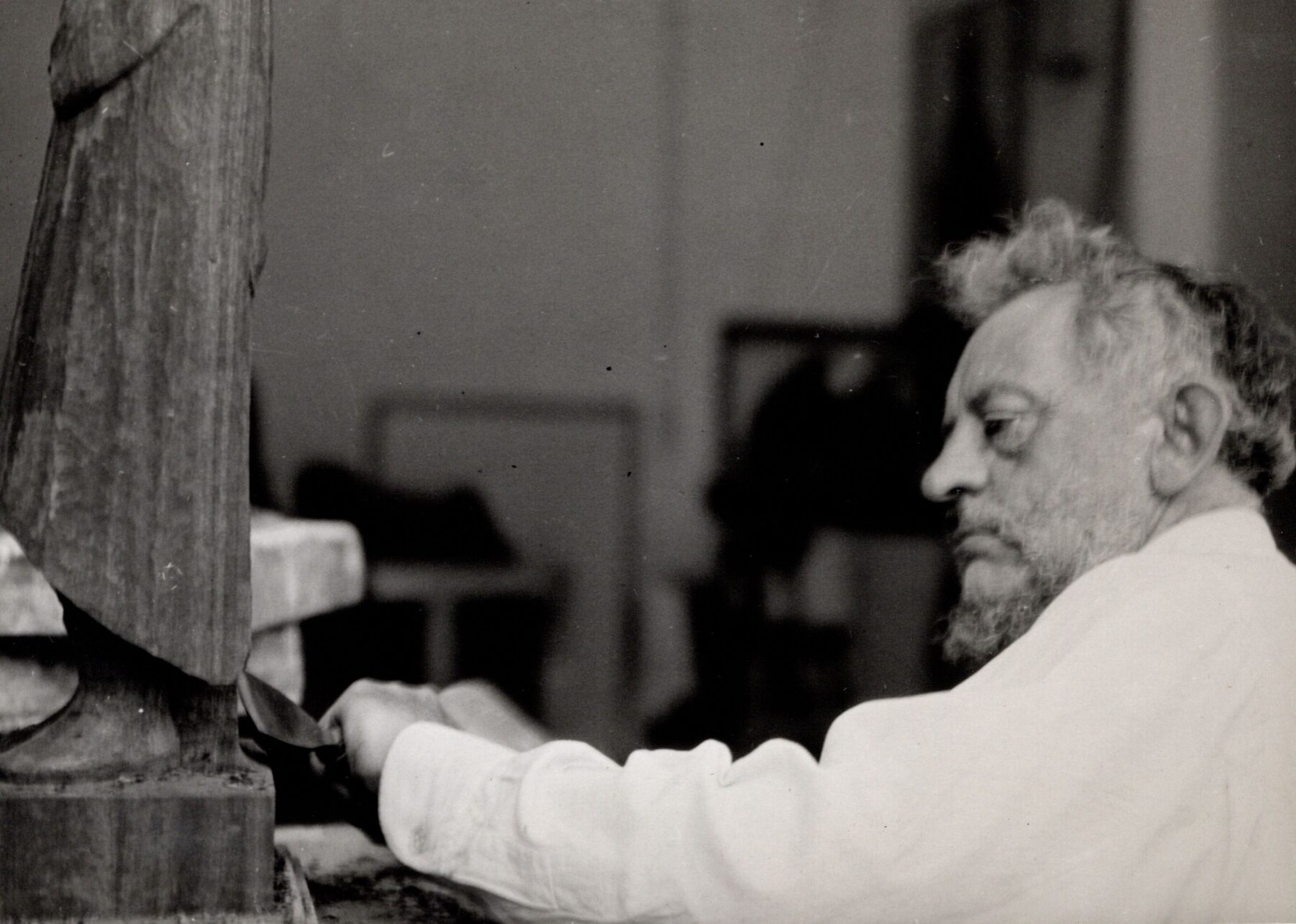 Das Bild zeigt eine Fotografie aus dem Jahr 1933, darauf ist der Künstler Ernst Barlach zu sehen, wie er an einer Skulptur arbeitet.